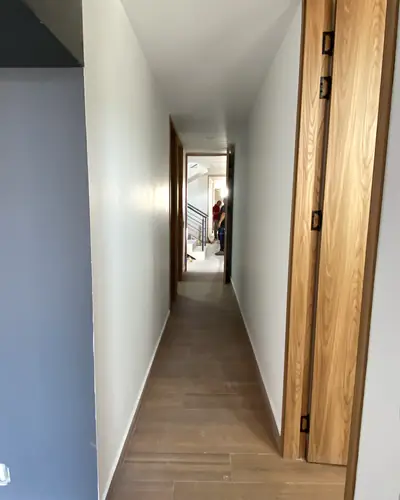 Pasillo terminado con puertas en madera y piso laminado