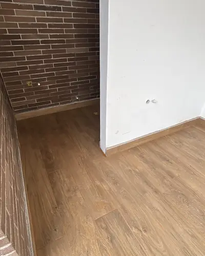Encuentro de piso en madera con muro en ladrillo