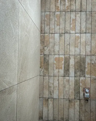 Baño con enchape en piedra y porcelanato de gran formato
