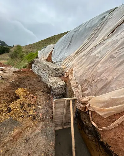 Construcción de muro de contención en gaviones junto a un talud protegido
