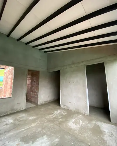 Interior en obra gris con vigas metálicas a la vista