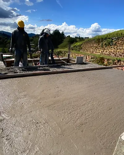 Placa de concreto recién vaciada con el equipo de obra