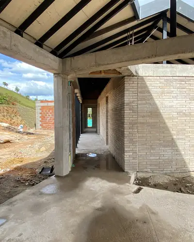 Corredor cubierto con estructura de madera y muros en bloque