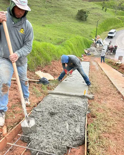 Equipo de obra vaciando concreto en placa huella