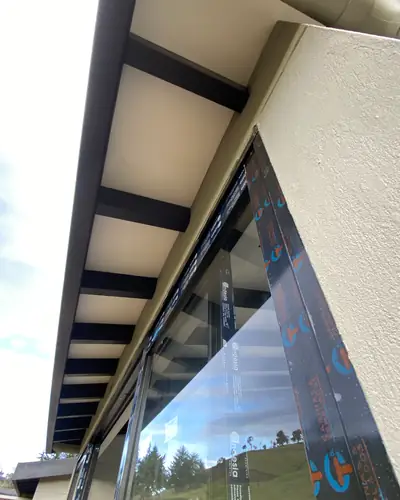 Ventanal de piso a techo bajo alero con vigas metálicas